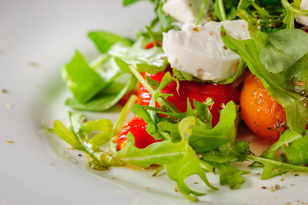 Warm salad with Tomatoes, ruccola, spinach, cooked bell pepper and cheese - Foto, Imagen