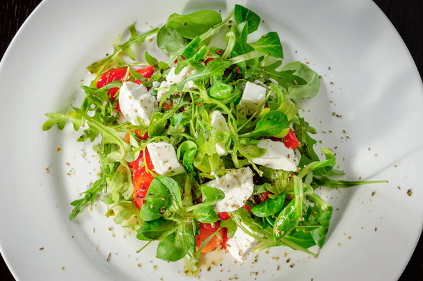 Warm salad with Tomatoes, ruccola, spinach, cooked bell pepper and cheese - Photo, Image