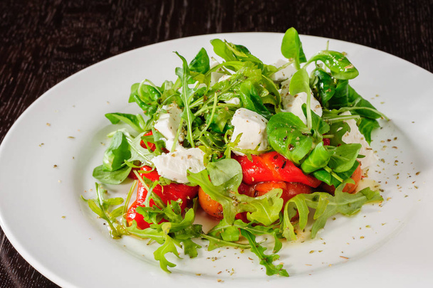 Warm salad with Tomatoes, ruccola, spinach, cooked bell pepper and cheese - Foto, afbeelding