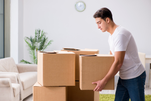 Молодий чоловік рухає коробки вдома
 - Фото, зображення