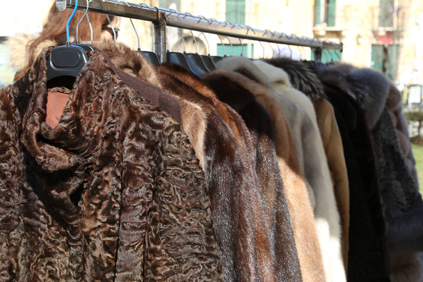 Pelzmäntel und Kleidung zum Verkauf im Kleiderbügel auf dem Flohmarkt - Foto, Bild