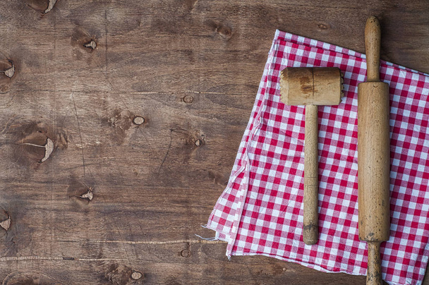 Деревянные кухонные принадлежности на красной салфетке, скалка и молоток для
 - Фото, изображение