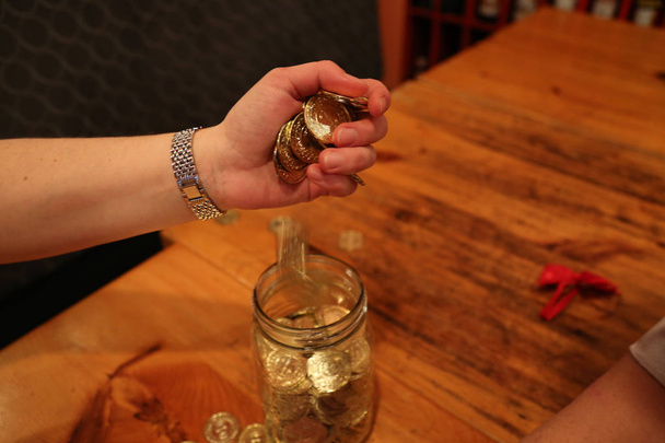 Concepto ahorro joven mujer mano sobre monedas
 - Foto, imagen