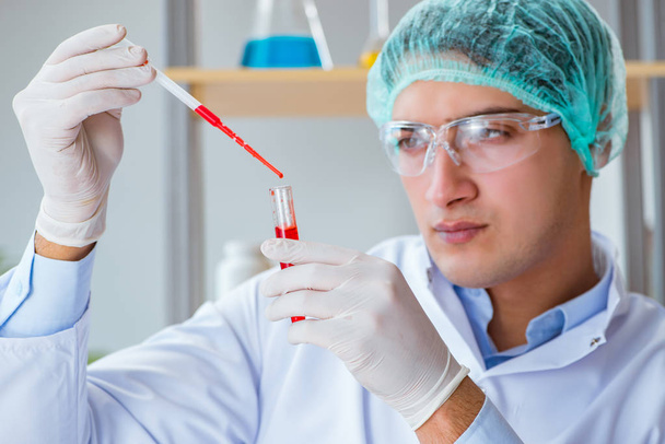 Young doctor working on blood test in lab hospital - Foto, Bild