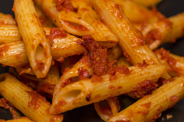 Italské potraviny - Penne al'arrabbiata (Angry pera), recept na klasické italské těstoviny s pikantní rajčatovou omáčkou, červené feferonky a petrželkou. - Fotografie, Obrázek