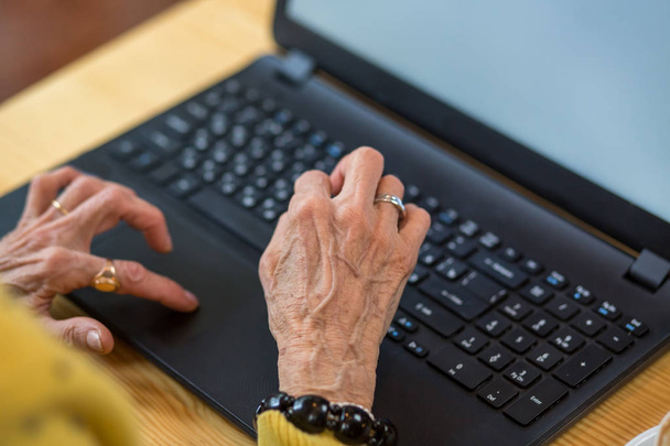Ноутбук і старі жіночі руки
. - Фото, зображення