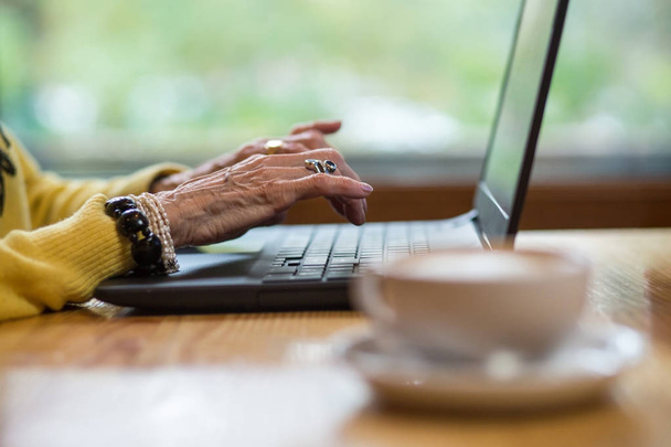 Laptop and old hands. - 写真・画像
