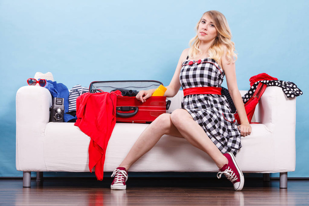 Woman choosing things to pack into suitcase - Foto, Imagen