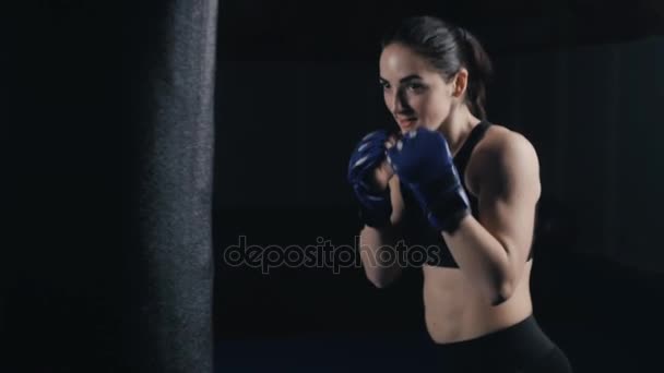 Kickboxing woman training punching bag in fitness studio - Footage, Video