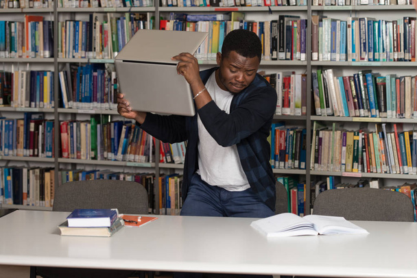 Estudante irritado quer quebrar seu laptop
 - Foto, Imagem