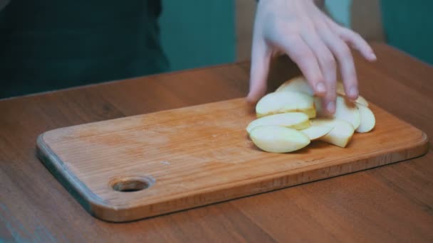 Woman Hands with a Knife Sliced Apple on a Wooden Kitchen Board in a Home Kitchen - Video, Çekim