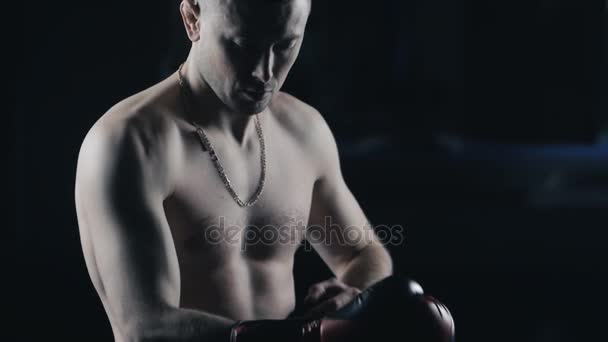 Sportler Kickboxer zieht Boxhandschuhe an - Filmmaterial, Video