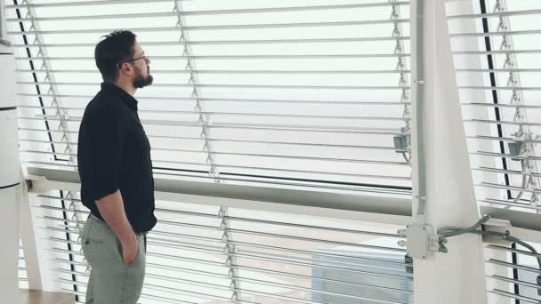 Nuori liikemies katselee ikkunasta
 - Materiaali, video