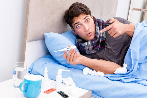 Άρρωστος άρρωστος άνθρωπος στο κρεβάτι που παίρνει φάρμακα και φάρμακα - Φωτογραφία, εικόνα