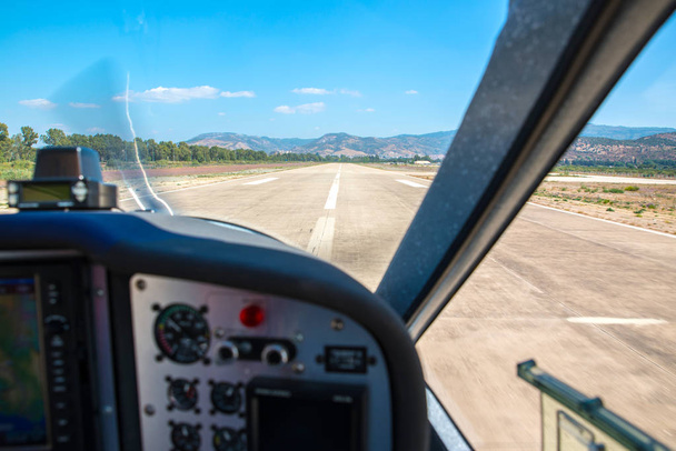 Kleine luchtvaartuigen op een lokale luchthaven. Wazig en uit focus cockpit, selectieve aandacht op de start-en landingsbaan en het landschap . - Foto, afbeelding