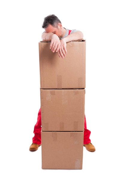 Tired man standing being pile of cardboard boxes - Photo, Image