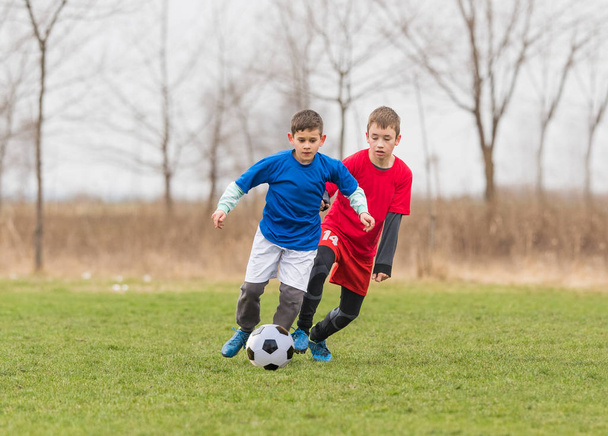 Gyerekek labdarúgás labdarúgó - gyermekek játékos mérkőzés futballpályán  - Fotó, kép