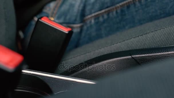 Male hand fastening car safety seat belt while sitting inside of vehicle before driving - Footage, Video