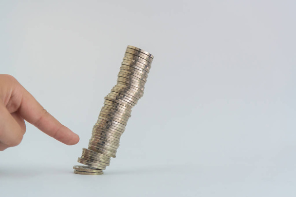 Finger pushing a pile of coins, column of coins falls , business - Foto, afbeelding