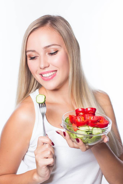 若くてきれいな女性は、野菜サラダを食べる。健康的な食事。形にする. - 写真・画像