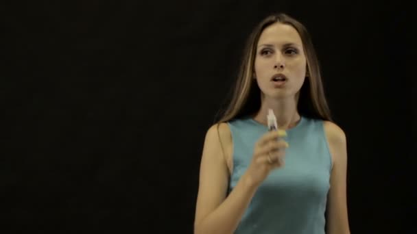 Young beautiful girl smokes electronic cigarette - Video, Çekim