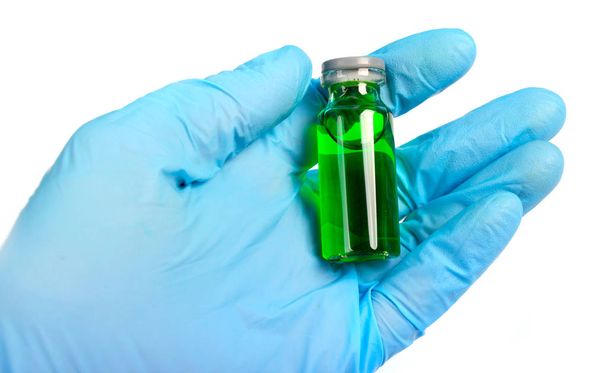 φιαλίδιο με εμβόλιο ή θεραπεία για κρατώντας ένα μπλε γάντια - Φωτογραφία, εικόνα