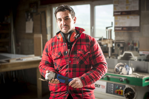 Carpenter holding power tool in his workshop - Photo, Image