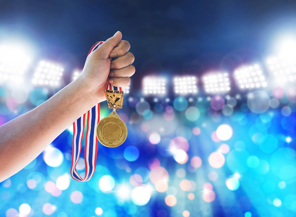 Man holding up a gold medal against,win concept. - Photo, Image