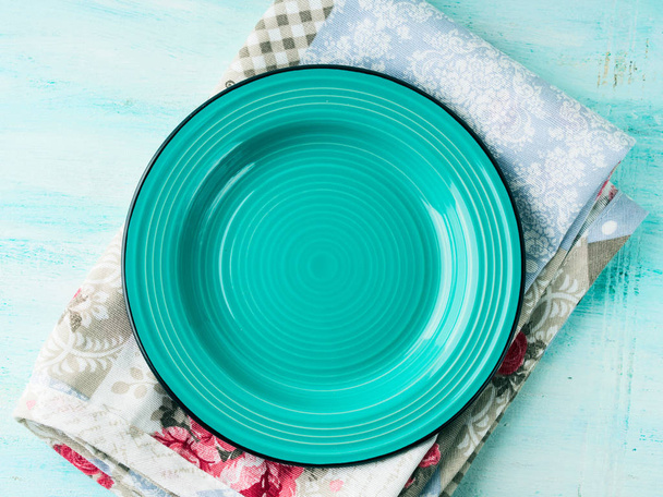 Зеленая тарелка на старинной салфетке деревянный текстурированный фон
 - Фото, изображение