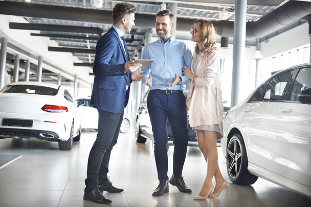 Couple and car salesman in shop - Photo, Image