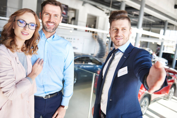 Couple and car salesman in shop - Photo, Image