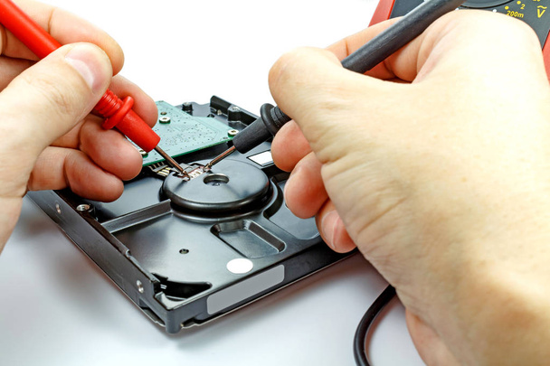 Testing hard disk drive by engineer on a white background - Zdjęcie, obraz