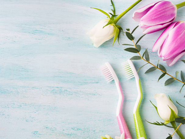 Twee pastel tandenborstels met bloemen kruiden. Lente kleuren - Foto, afbeelding