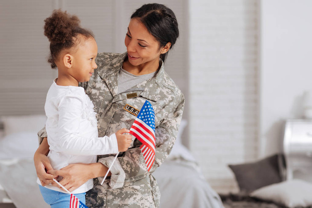 child and her mom holding little flags - Photo, image