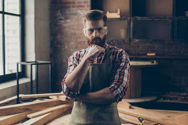 Portrait of brutal handsome concentrated woodworker holding his  - Valokuva, kuva