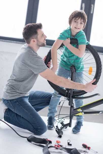 father and son repairing bicycle  - Фото, зображення