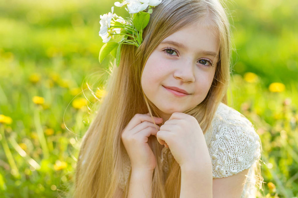 A beautiful little girl runs through a flowering garden in the s - Foto, afbeelding