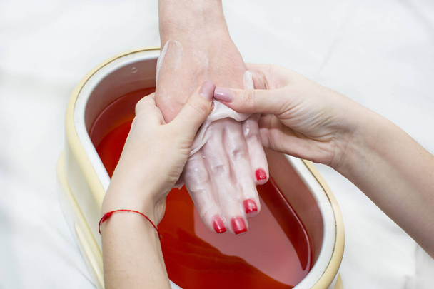 proceso de tratamiento de parafina de las manos femeninas
 - Foto, imagen