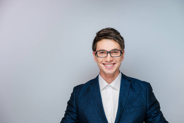 A young guy in a business suit and glasses smiling at the camera - Foto, Imagen
