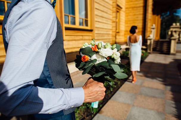 Наречений тримає весільний букет з троянд для красивої нареченої
 - Фото, зображення