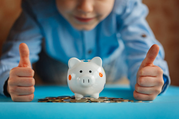 Hands kid and piggy bank or money box. - Zdjęcie, obraz