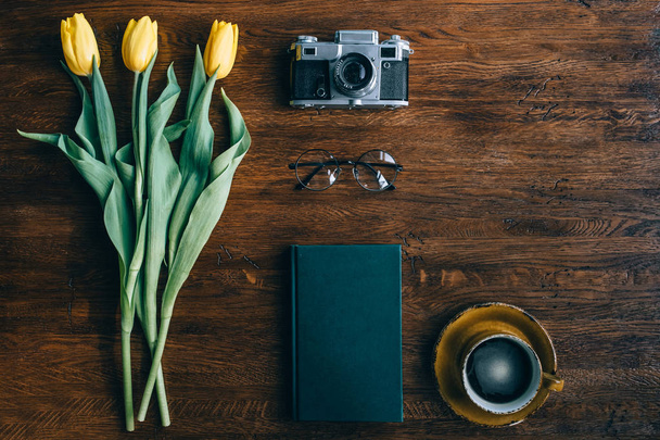 Tabel voorjaar, tulpen, notebook, koffie, camera. Bovenaanzicht, platte l - Foto, afbeelding