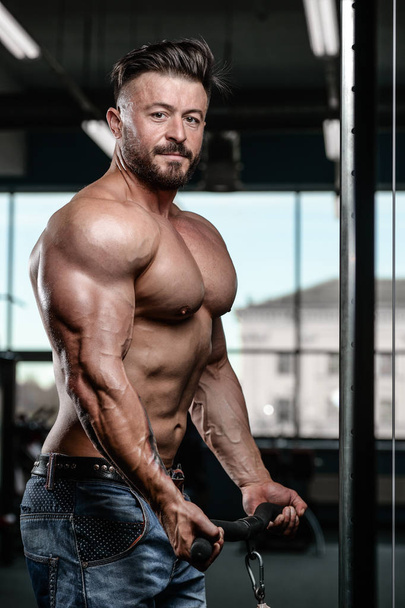 Brutal strong bodybuilder man pumping up muscles and train gym - Foto, Imagem
