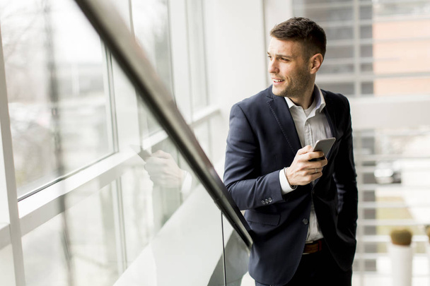 Businessman with smartphone in the office - Zdjęcie, obraz