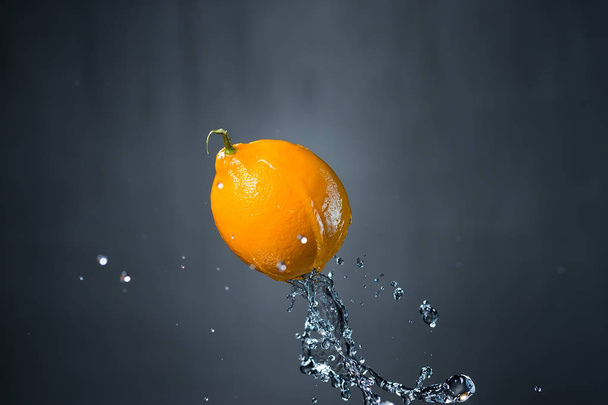 lemon and splash of water on gray background - Foto, Bild