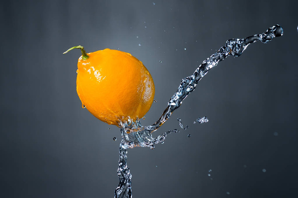 lemon and splash of water on gray background - Фото, зображення
