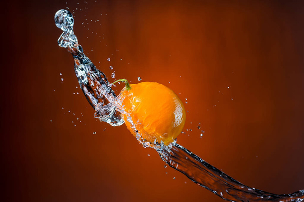 lemon and splash of water on orange background - Foto, Imagem