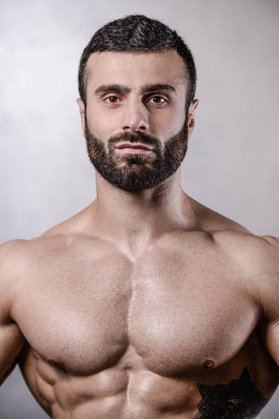 Brutal fort bodybuilder homme posant en studio sur fond gris
 - Photo, image