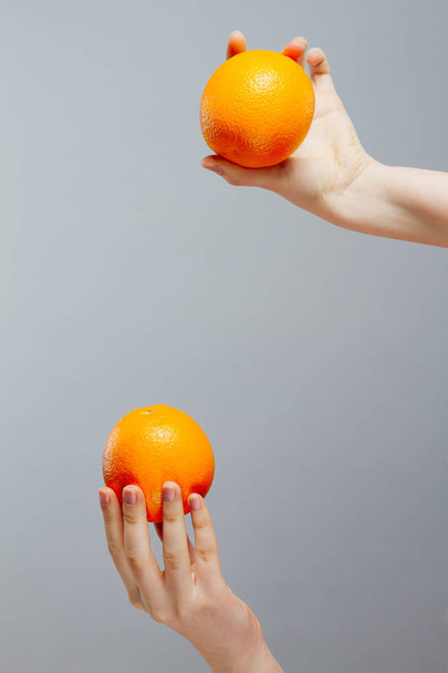 Chinese Orange on Asian woman hand on gray concrete background - Fotoğraf, Görsel