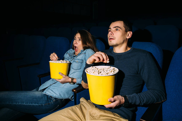 Cinema Day. Young couple watching a thriller movie in cinema. Date. - Foto, imagen